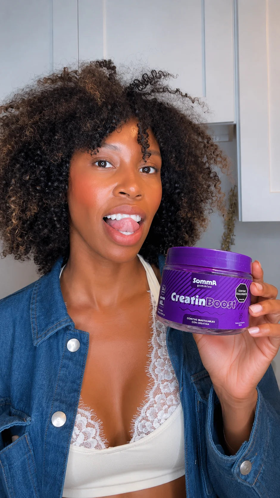 Mujer mostrando un frasco de Somma Gummies CreatinBoost