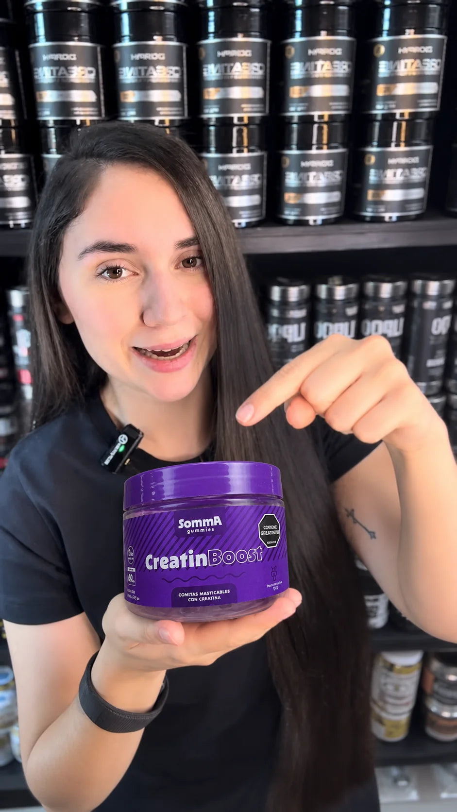 Mujer mostrando un frasco de Somma Gummies CreatinBoost