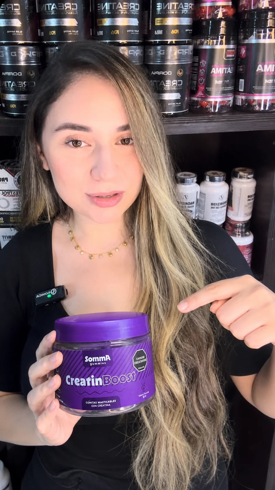 Mujer mostrando un frasco de Somma Gummies CreatinBoost